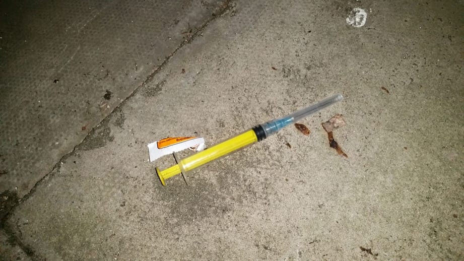A hyperdermic carelessly discarded by a drug addict.