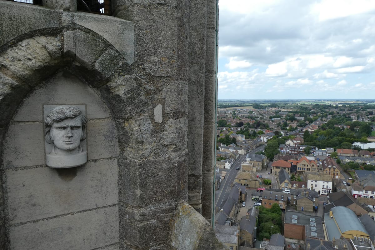 A carved head high on the tower, looking out over the town far below A carved head high on the tower, looking out over the town far below