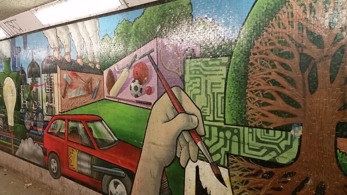 A painted hand at work, among a combustion engined car, sport and circuitry A painted hand at work, among a combustion engined car, sport and circuitry